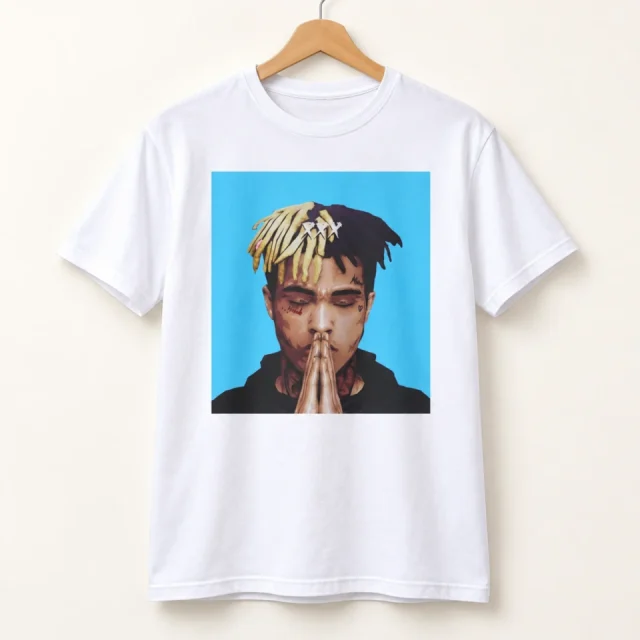 Studio view of a T-shirt with xXXTentacion portrait with two-tone hair on a cyan background